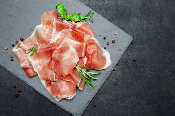 istock Italian prosciutto crudo or spanish jamon. Raw ham on stone cutting board 930440462