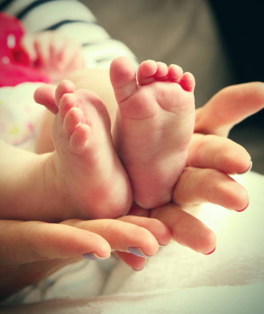 istock Baby feet in mum hands 930444368
