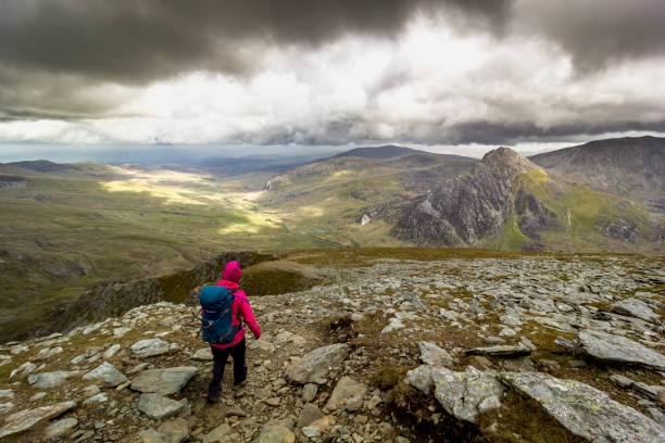 Hiking in Snowdonia National Park, Wales, UK. Images taken in Autumn and Summer 2015 in Snowdonia (Welsh: Eryri), a mountainous region in north west Wales and a national park. A hiker walks up a pass in Snowdonia. wales mountain mountain range hill stock pictures, royalty-free photos & images
