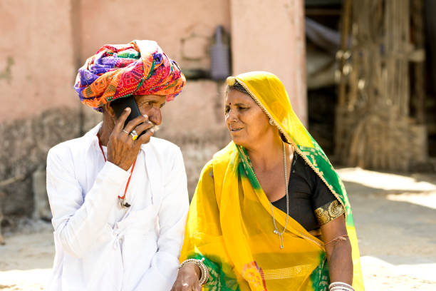 istock Indian couple in traditional clothing using mobile phone 930445276