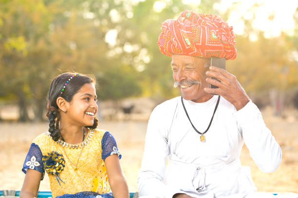 istock Rural girl with father talking on mobile phone 930445476