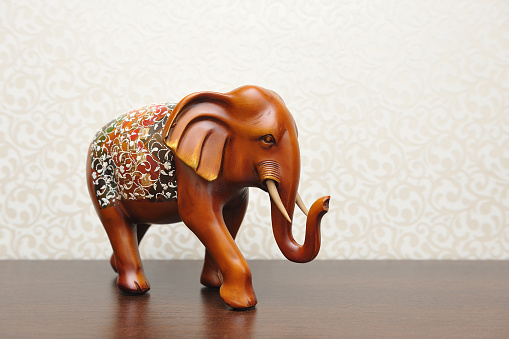 Wooden figure of an elephant in a home interior. Brown color.