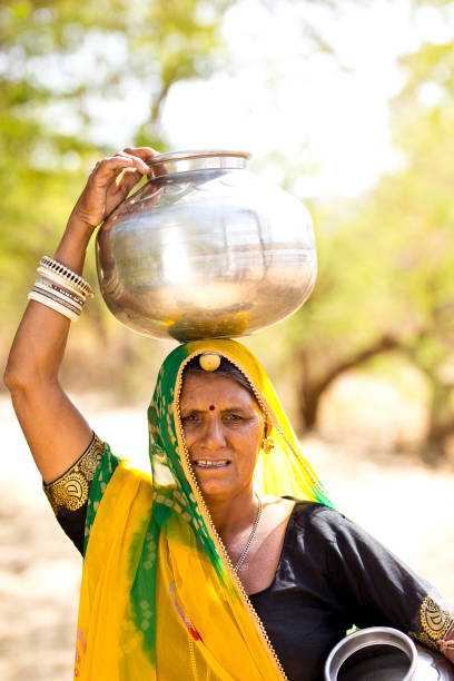 istock Indian woman carrying water pots on her head 930455398