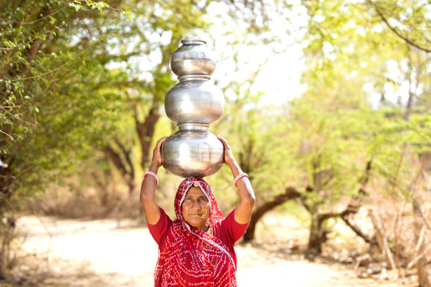 istock Indian woman carrying water pots on her head 930455550