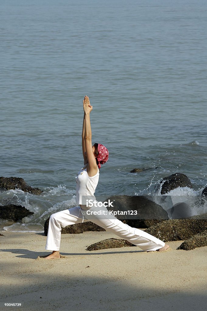 virabhadrasana, hatha yoga by the beach  Beach Stock Photo