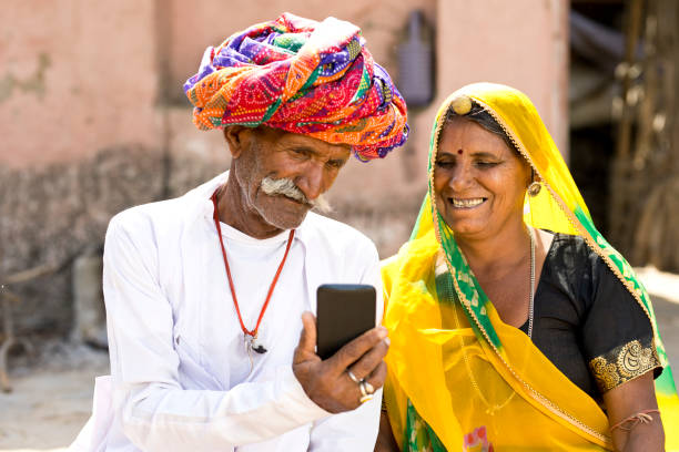 istock Indian couple in traditional clothing using mobile phone 930457970