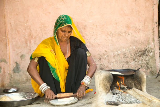istock Rural Indian woman rolling dough 930458214