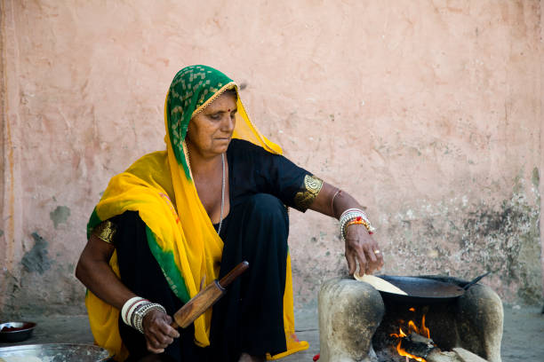 istock Rural Indian woman rolling dough 930458310