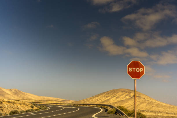 istock A stop sign on a road in a sand desert 930467854