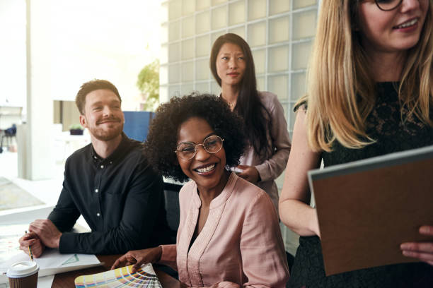 istock Positive work colleagues smiling together in a modern office 930475834