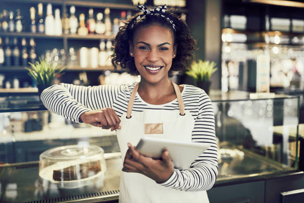 istock Smiling African entrepreneur standing in her cafe with a tablet 930476990