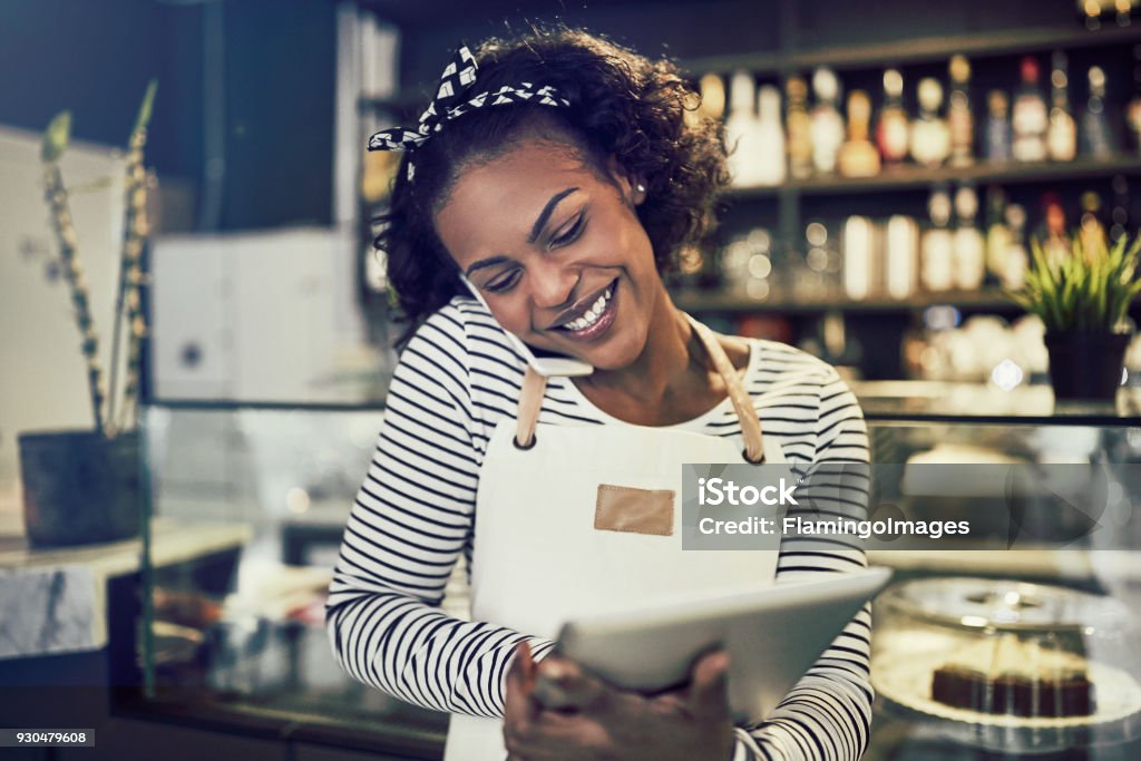 Souriante jeune entrepreneur africain occupé à travailler dans son café - Photo de Petite entreprise libre de droits