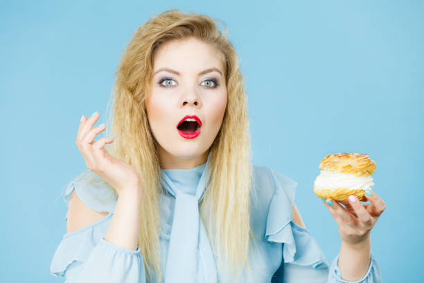 istock Funny woman holds cream puff cake 930479934