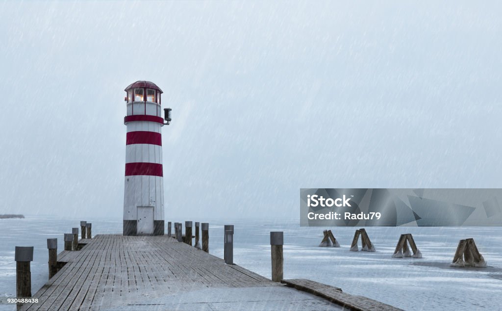 Lighthouse at sunrise with fog and rain during winter Austria Stock Photo