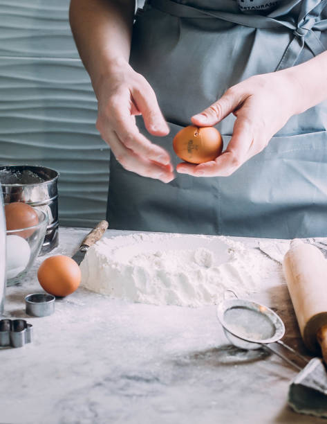 istock Woman Chef broken egg in flour. Ingredients for dough making. Bakery or Baking Concept. 930489724