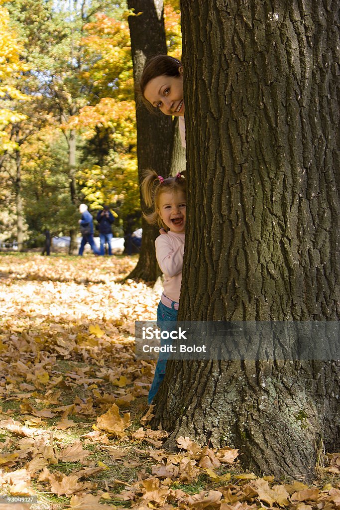 Mère et la petite fille se cacher derrière un arbre - Photo de 20-24 ans libre de droits