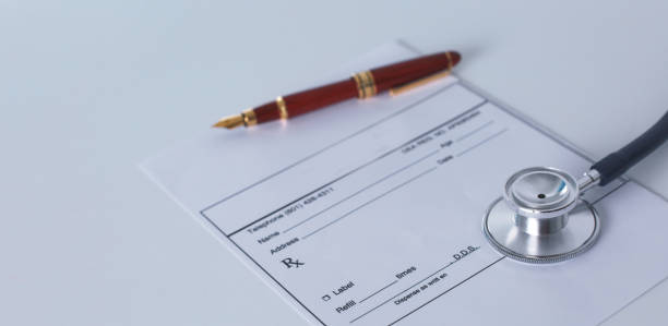 istock Doctor's workspace working table with patient's discharge blank paper form, medical prescription, stethoscope on desk 930491900