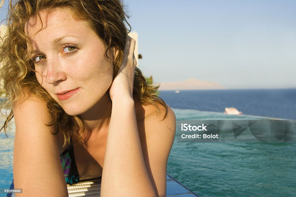 Bellezza Sdraiati sul bordo della piscina infinity - Foto stock royalty-free di Adulto