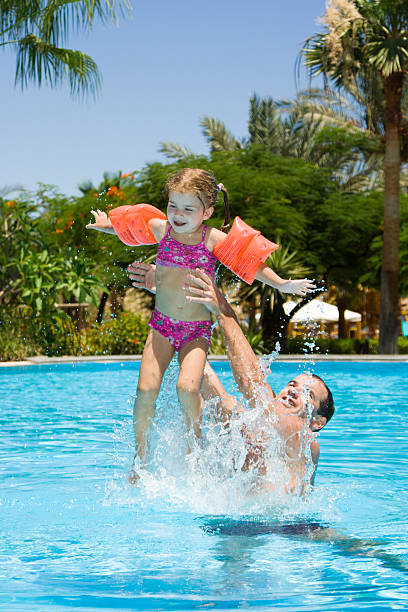 istock Father and little daughter playing in pool 93049531
