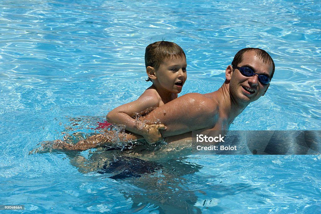 Padre e figlio giocano in piscina - Foto stock royalty-free di 20-24 anni