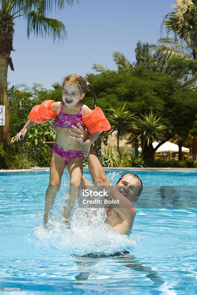 Pai e filha jogando na piscina pequena - Foto de stock de Boia de Braço royalty-free