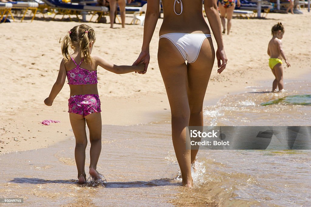 Dziewczynka spaceru na plaży z jej Matka - Zbiór zdjęć royalty-free (Para - Stosunki międzyludzkie)