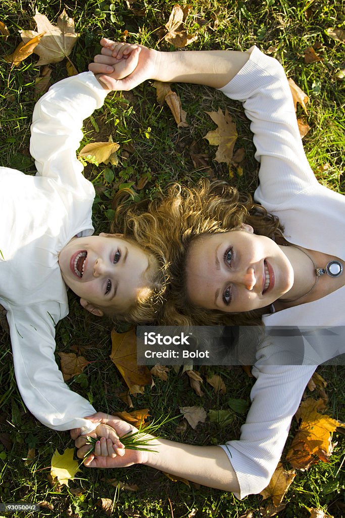 Madre e hija jugando en el parque otoño - Foto de stock de 20 a 29 años libre de derechos