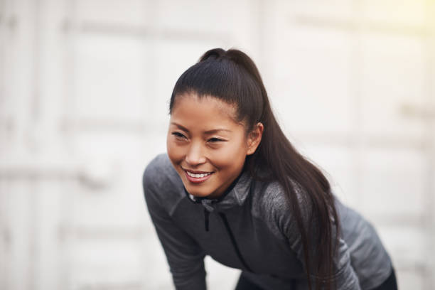 istock Fit young Asian woman taking a break from a run 930502102