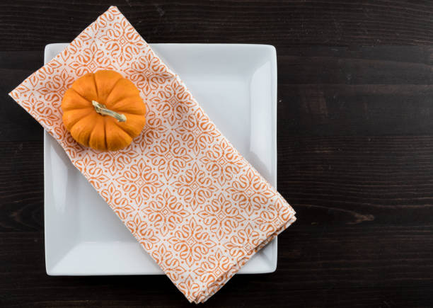 istock Orange Napkin and Small Pumpkin Diagonal On Square Plate 930505468