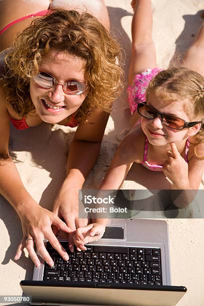 Mutter Und Tochter Mit Laptop Am Strand Stockfoto und mehr Bilder von Alleinerzieherin - Alleinerzieherin, Bikini, Computer