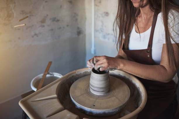 istock Creative artisan shaping clay on a wheel in her studio 930507832