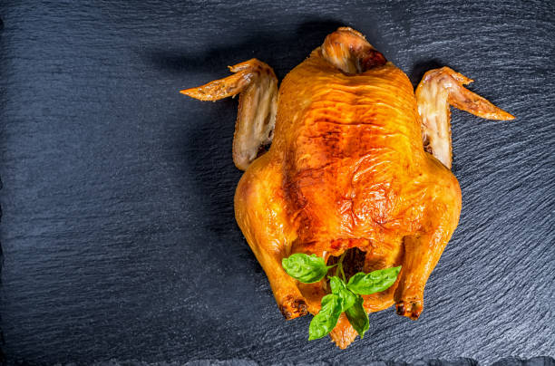 istock roasted chicken with green basil twig on slate stone background, flat design, close up 930508624