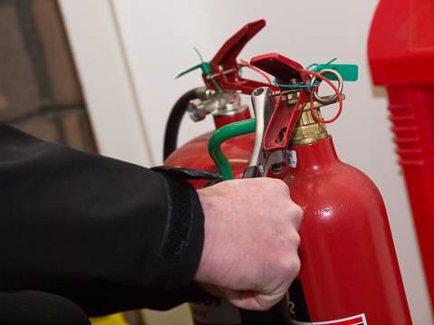 An engineer servicing a fire extinguisher