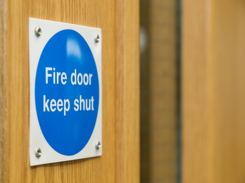 A fire door sign, screwed into a fire door