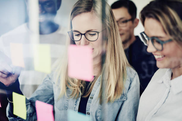 istock Diverse businesspeople brainstorming on a glass wall in an office 930509538