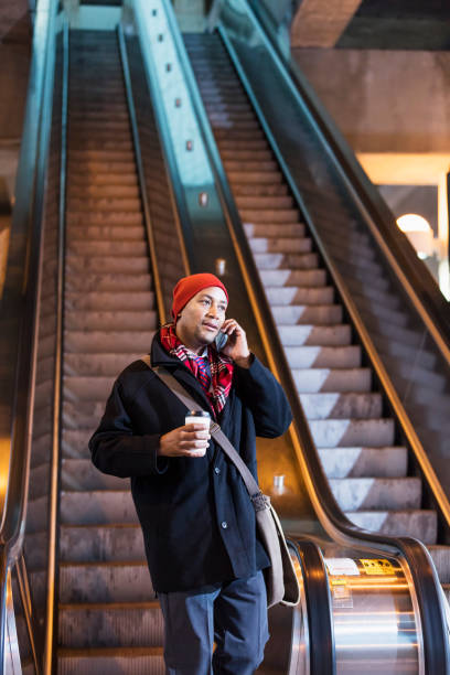 istock African-American man riding an escalator 930523036