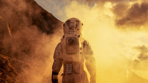 istock Courageous Astronaut in the Space Suit Explores Red Planet Mars Covered in Mist. Adventure. Space Travel, Habitable World and Colonization Concept. 930523144