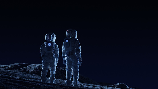Dos astronautas en trajes espaciales están en los planetas alienígenas observar terrenos extraterrestres. Recorrido de espacio y concepto de colonización extraterrestre. photo