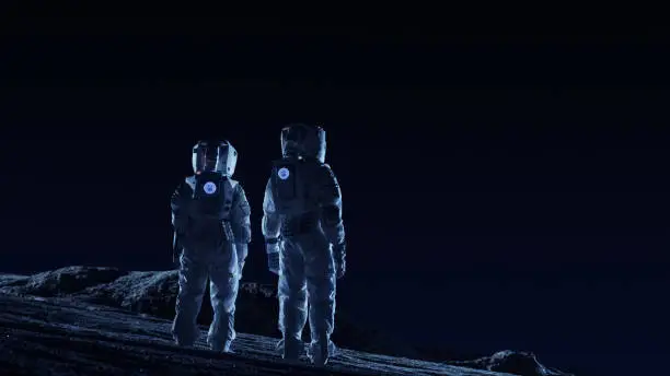 Photo of Two Astronauts in Space Suits Stand on the Alien Planets Observing Extraterrestrial Terrain. Space Travel and Extraterrestrial Colonization Concept.