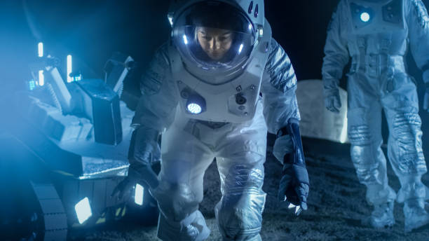 istock Two Astronauts on an Alien Planet Discover Something Interesting on the Ground. Space Travel and Solar System Colonization Concept. 930523306