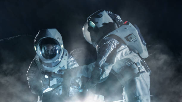 istock Two Astronauts in Space Suits on an Alien Planet Prepare Space Rover for Surface Exploration Mission. Futuristic Concept about Space Travel and Colonization. 930523352