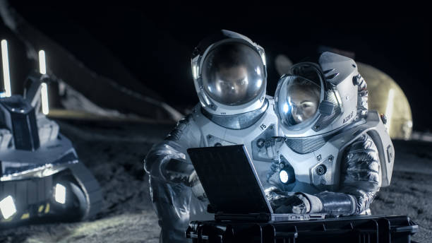 istock Two Astronauts Wearing Space Suits Work on a Laptop, Exploring Newly Discovered Planet, Send Communicating Signal to Earth. Space Travel, Interstellar Exploration and Colonization Concept. 930523384