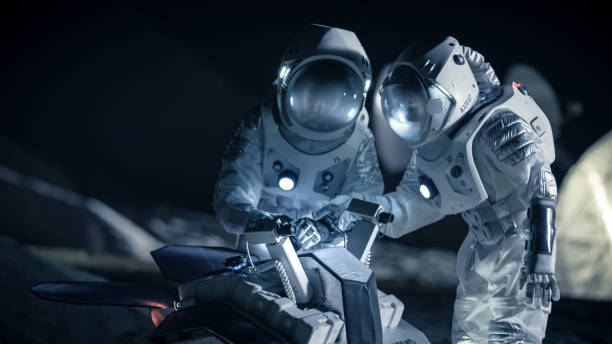 dois astronautas em trajes espaciais num planeta alienígena preparem espaço rover para expedição de exploração de superfície do planeta. viagem espacial e o conceito de colonização do sistema solar. - colonization - fotografias e filmes do acervo