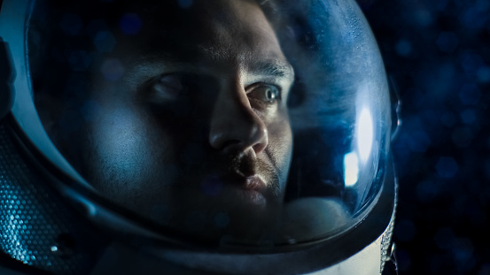 Toma de retrato del astronauta Courageuos llevaba casco en el espacio, mirando a su alrededor con asombro. Viajes espaciales, exploración y concepto de colonización del Sistema Solar. photo