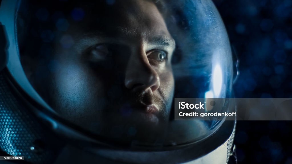 Portrait Shot of the Courageuos Astronaut  Wearing Helmet in Space, Looking around in Wonder. Space Travel, Exploration and Solar System Colonization Concept. Astronaut Stock Photo