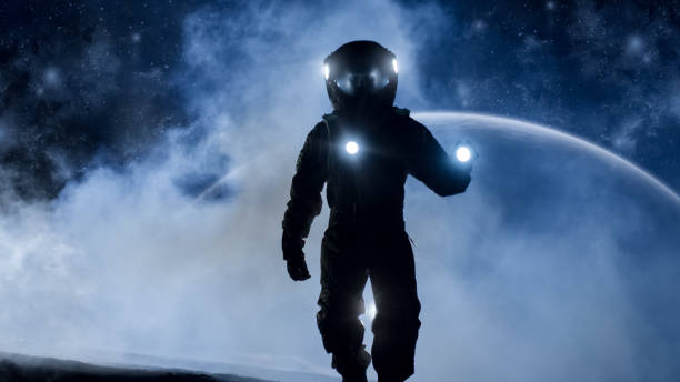 istock Courageous Astronaut in the Space Suit Holds Flashlight and Explores Mysterious Alien Planet Covered in Mist. Other Planet in Background. Adventure. Space Travel, Habitable World and Colonization Concept. 930523438
