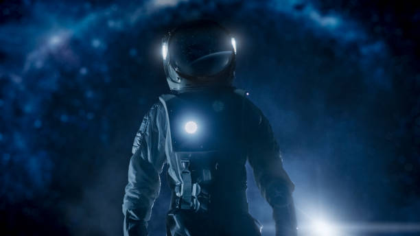 istock Courageous Astronaut in the Space Suit with Flashlight Explores Mysterious Alien Planet. The Milky Way Galaxy in Background. Adventure. Space Travel, Habitable World and Colonization Concept. 930523442