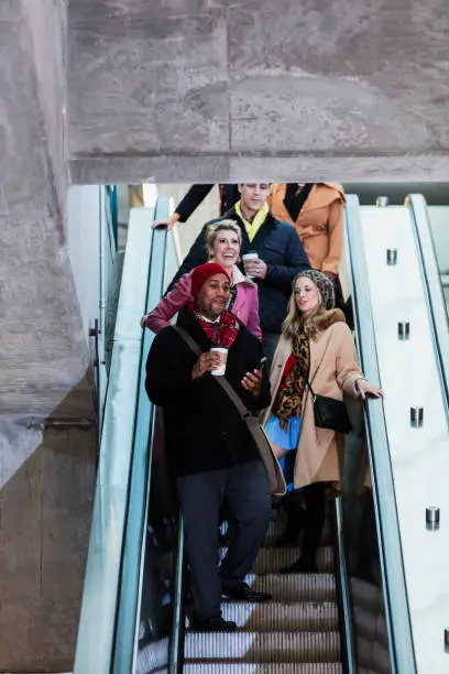 Photo of Commuters on way to work, riding escalator