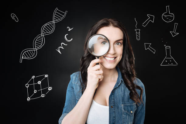 istock Cheerful student looking through the magnifying glass and smiling 930527610