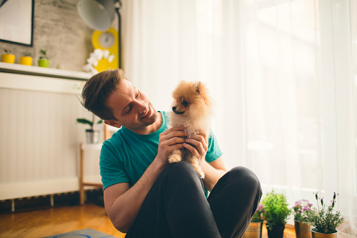 Portrait of mid adult man with his Pomeranian dog.
